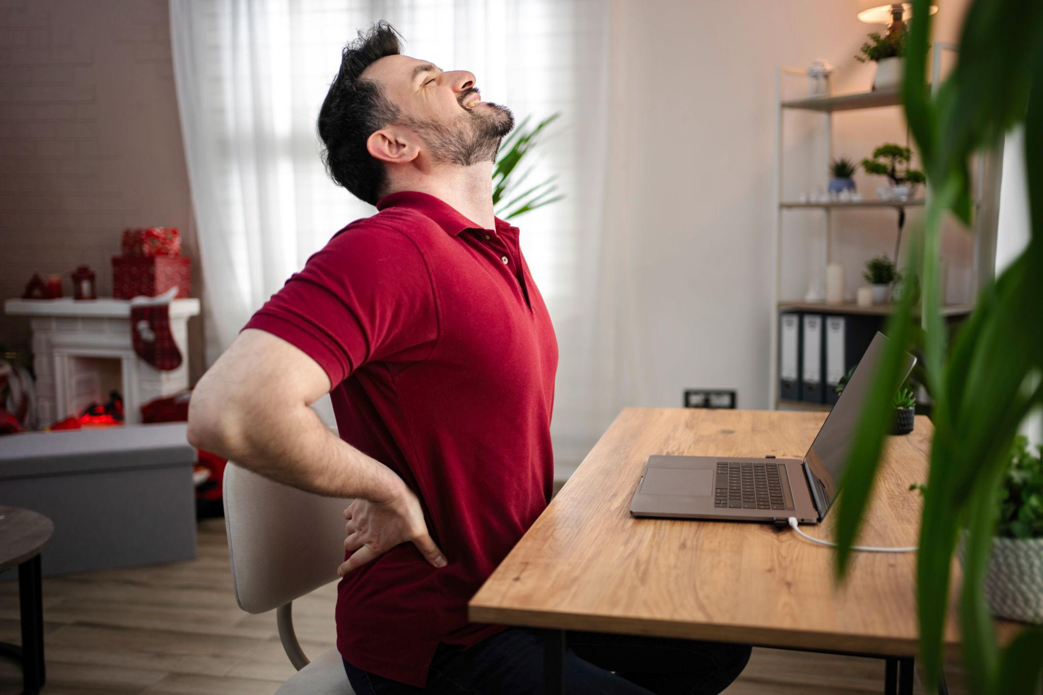 persona trabajando sentada con dolor de espalda en la zona lumbar